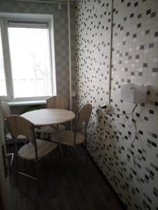 アニークシュチェイにあるNakvynė Anykščių centreのテーブルと椅子、窓が備わる客室です。