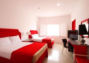 um quarto de hotel com duas camas e uma televisão em Zar Queretaro em Querétaro