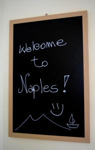 a chalkboard with the words welcome to nugges written on it at A casa di Peppe in Naples