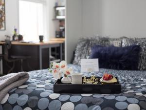 a tray with a plate of food on a bed at Downtown Memphis Shellcrest Apartments in Memphis