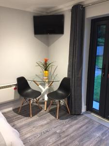 a dining room with two chairs and a glass table at Tudor Lodge Guest Accommodation in Bunratty