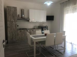 een keuken met een tafel en stoelen in een kamer bij Solemar in Giardina Gallotti