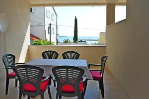 einen weißen Tisch und Stühle auf dem Balkon in der Unterkunft Apartments Mačak in Novalja