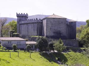 um grande castelo no topo de uma colina verde em Pensión Risco em Vimianzo