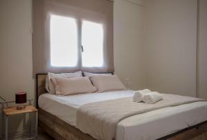 sypialnia z łóżkiem i dwoma ręcznikami na nim w obiekcie BO Home w mieście Suda