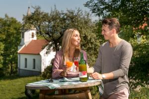 a man and woman sitting at a table with a bottle of wine at Willi's Bauernhof in Leiben