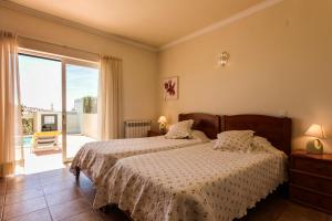 una camera da letto con due letti e una grande finestra di Villa Acacias 13 a Luz Altre 36 foto