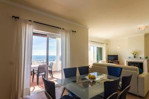 un soggiorno con un divano e un tavolo con sedie di Villa Acacias 13 a Luz