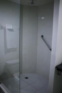 a shower with a glass door next to a toilet at Zar Guadalajara in Guadalajara