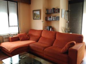 un divano marrone in soggiorno con tavolo in vetro di Wellington a Vitoria-Gasteiz