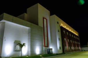 un edificio con una palma di fronte ad esso di notte di Zar Coatzacoalcos a Coatzacoalcos