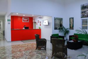 une salle d'attente avec des chaises et un mur rouge dans l'établissement Zar Coatzacoalcos, à Coatzacoalcos