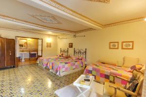 a hotel room with two beds and two tables at Posada de Los Aceiteros in Ahigal de los Aceiteros