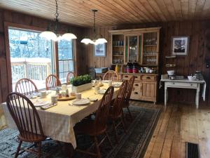 a dining room with a table and chairs in a kitchen at Timberholm Inn in Stowe
