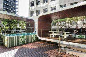 a deck with benches and tables on a building at Apartmentsouthbank in Melbourne