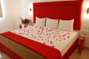 a bedroom with a bed with pink flowers on it at Hotel Zar Merida in Mérida