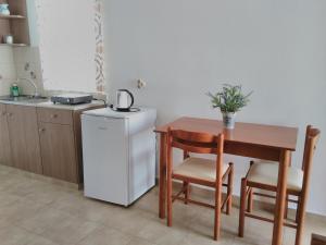 a small kitchen with a table and a refrigerator at Maria Studios and Apartments in Haraki