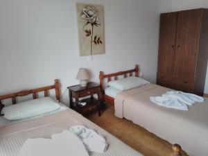 a bedroom with two beds and a night stand with a lamp at Maria Studios and Apartments in Haraki