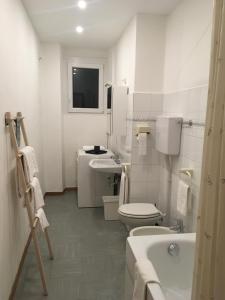 een witte badkamer met een toilet en een wastafel bij Appartamento Duca in Trento