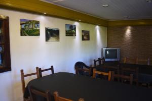 a dining room with a table and a tv at Esquina Apart in Esquina