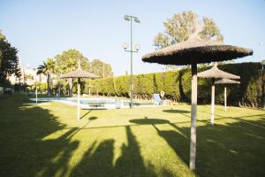 a park with umbrellas in the grass at Cozy Apartment Banus in Marbella