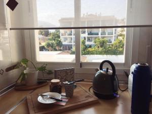 a kitchen counter with a window and a table with utensils at Cozy Apartment Banus in Marbella