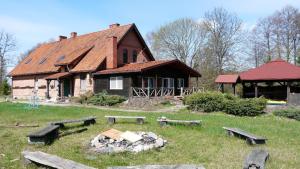 an old house with a group of benches in front of it at Siedlisko Szwałk in Szwalk