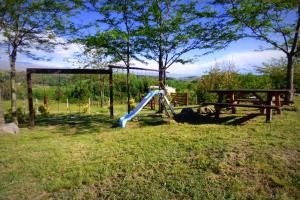un parque infantil con tobogán y mesa de picnic en Terrazas al Champaqui en Villa Yacanto