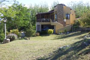 a house on a hill with a yard at Terrazas al Champaqui in Villa Yacanto