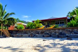 a house on the beach with a rock wall at MOOREA - Fare Taina Nui in Haapiti