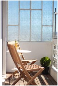 2 Stühle und ein Tisch in einem Zimmer mit Fenstern in der Unterkunft Oporto Downtown in Porto