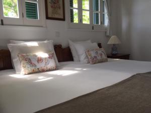 Una cama blanca con dos almohadas encima. en Monserrate - Galera Cottage, en Caloura