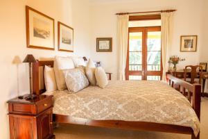 a bedroom with a bed with a table and a window at Mudgee Homestead Guesthouse in Mudgee