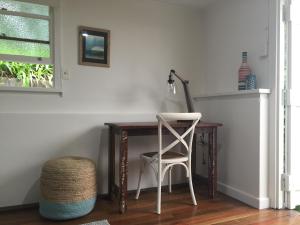 un escritorio con una silla y una lámpara. en Boatsheds en Sawtell