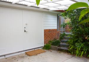 a garage with a white door and a brick wall at Boatsheds in Sawtell