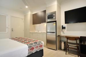 a hotel room with a bed and a kitchen at Northpoint Motel Apartments in Toowoomba