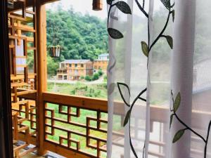 a window with a view of a mountain at Zhangjiajie one step to heaven inn (Yangjiajie ticket office) in Zhangjiajie