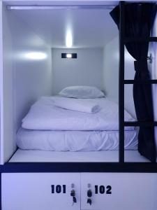 The 8 Capsule Hotel Bukit Bintang tesisinde bir odada yatak veya yataklar