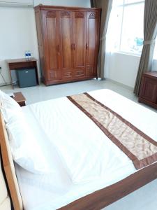 een groot wit bed in een kamer met een raam bij Sao Kim in Cà Mau