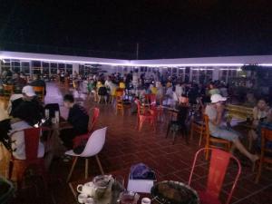 a group of people sitting at tables in a restaurant at night at Sao Kim in Cà Mau