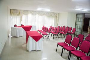 a conference room with red chairs and tables and tablesearcher at Hotel Dorado BAQ in Barranquilla +93 photos