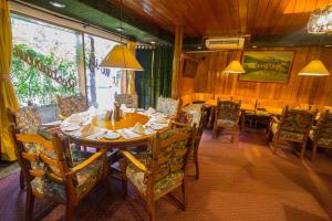 a dining room with a wooden table and chairs at Schweizer Hotel in Cebu City