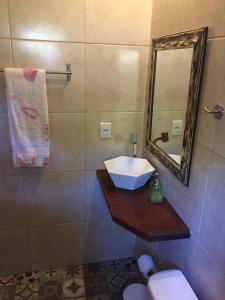 a bathroom with a sink and a mirror and a toilet at Casa Aluguel Abraão 3,Ilha grande in Abraão