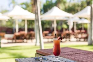 a drink is sitting on a wooden table at Cable Beach Club Resort & Spa in Broome