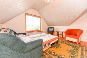 a bedroom with a bed and a couch and a chair at Birutes Houses in Druskininkai