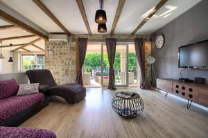 een woonkamer met een bank en een tv bij Stylish & luxury villa with pool, biliard, extra pool heating available - WiiBuk in Pula