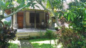 a house with a front porch with a table at Arjana Bungalows 2 in Ubud