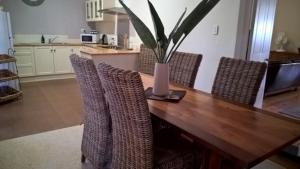 einem Esstisch mit Stühlen und einer Vase darauf in der Unterkunft Book Keepers Cottage in Waikerie + 7 Fotos