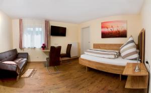 ein Schlafzimmer mit einem großen Bett und einem Sofa in der Unterkunft Gästehaus Hötzl in Galgweis