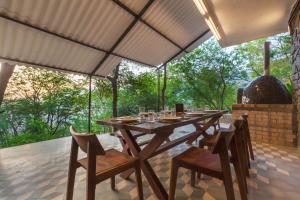 a table and chairs on a patio with a view at SaffronStays Inverlochy, Lonavala in Kārli